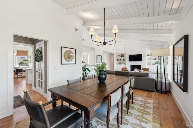 271 Via La Paz Rd, Greenbrae, CA 94904 - dining space with a fireplace, an inviting chandelier, vaulted ceiling with beams, baseboards, and light wood-style floors