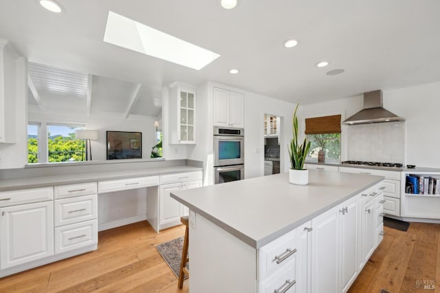 271 Via La Paz Rd, Greenbrae, CA 94904 - kitchen featuring light countertops, stainless steel appliances, wall chimney exhaust hood, and glass insert cabinets