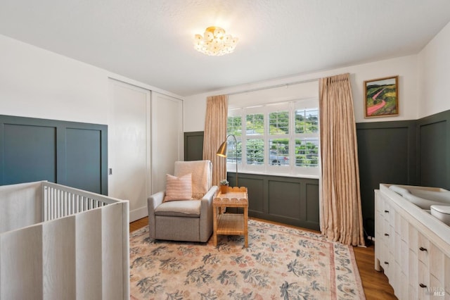 271 Via La Paz Rd, Greenbrae, CA 94904 - bedroom with wood finished floors, a closet, a wainscoted wall, a crib, and a decorative wall