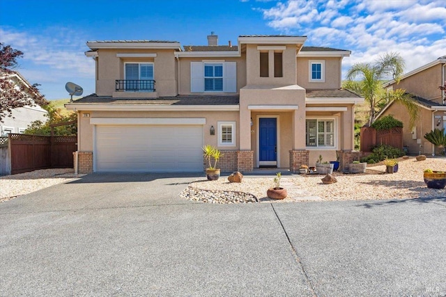 view of front of property featuring fence, driveway, stucco siding, and an attached garage
