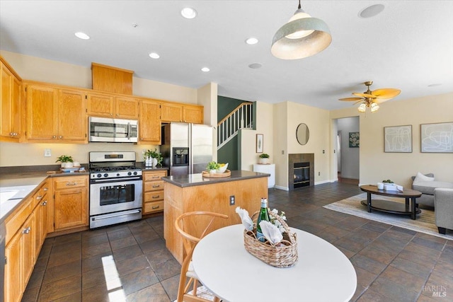 kitchen featuring stainless steel appliances, open floor plan, a kitchen island, recessed lighting, and baseboards