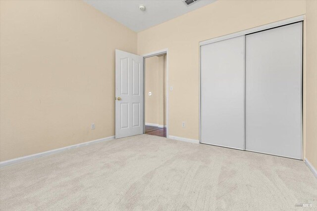 unfurnished bedroom with carpet floors, a closet, and baseboards