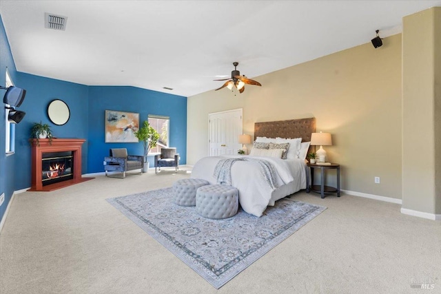 carpeted bedroom with a fireplace with flush hearth, baseboards, and a ceiling fan
