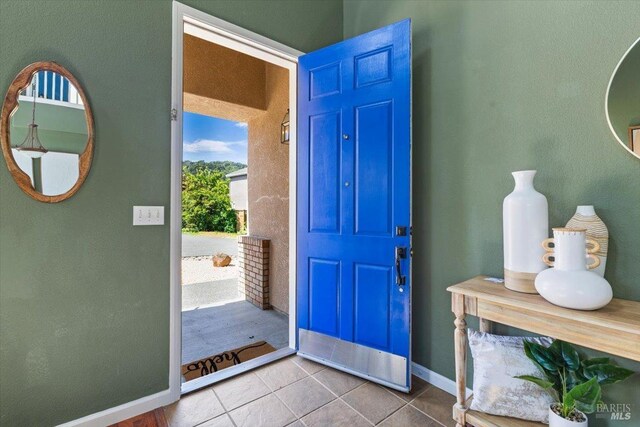 entryway with tile patterned flooring and baseboards
