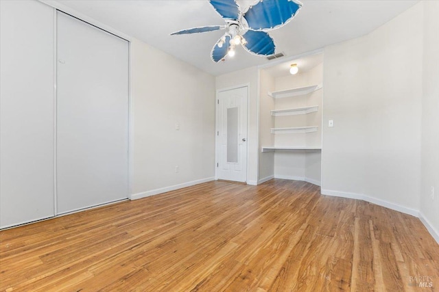 unfurnished bedroom with wood finished floors, baseboards, and ceiling fan