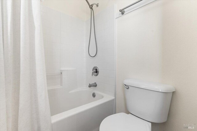 full bathroom with toilet and shower / bathtub combination with curtain