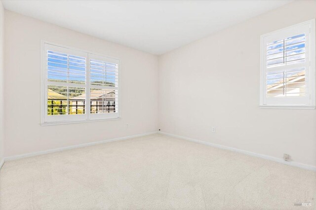 unfurnished room with carpet flooring and baseboards
