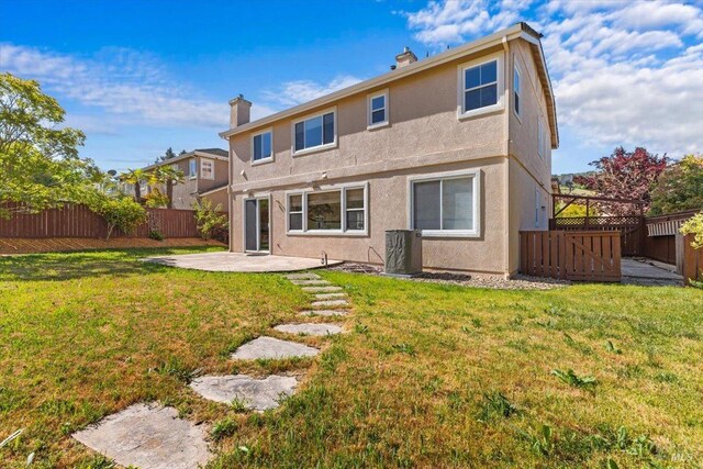 back of house featuring a patio area, a chimney, and stucco siding