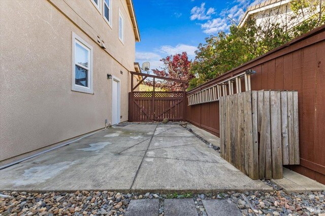 view of patio featuring fence and a gate