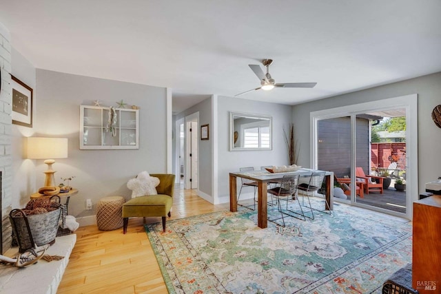 dining space with baseboards, wood finished floors, a ceiling fan, and a healthy amount of sunlight