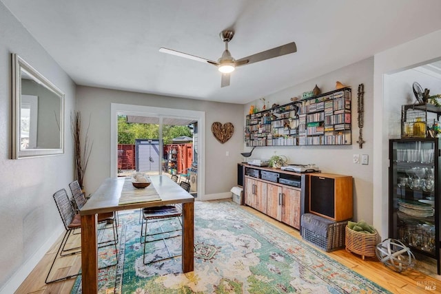 dining area featuring baseboards, light wood-style flooring, and a ceiling fan
