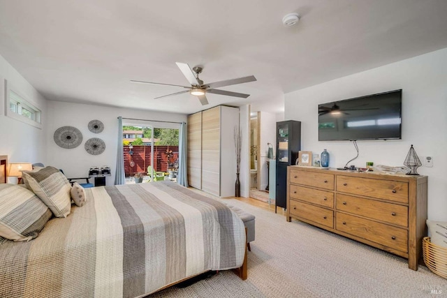 bedroom featuring connected bathroom, access to outside, and a ceiling fan