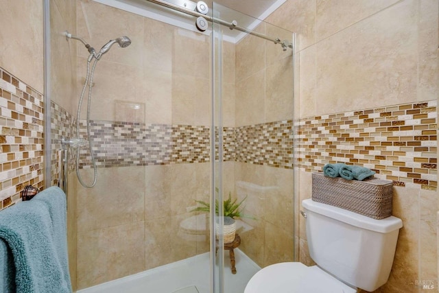 full bath with tile walls, toilet, and a shower stall