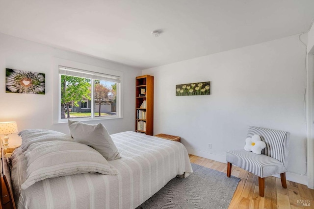 bedroom with light wood-style flooring and baseboards