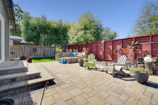 view of patio / terrace featuring an outdoor fire pit and a fenced backyard