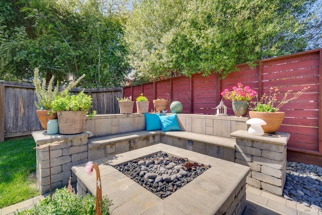 view of patio / terrace featuring an outdoor fire pit and a fenced backyard