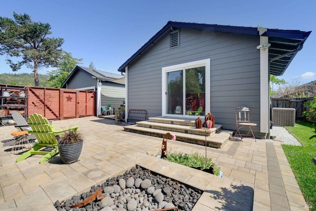 back of property with a patio area, a gate, fence, and entry steps