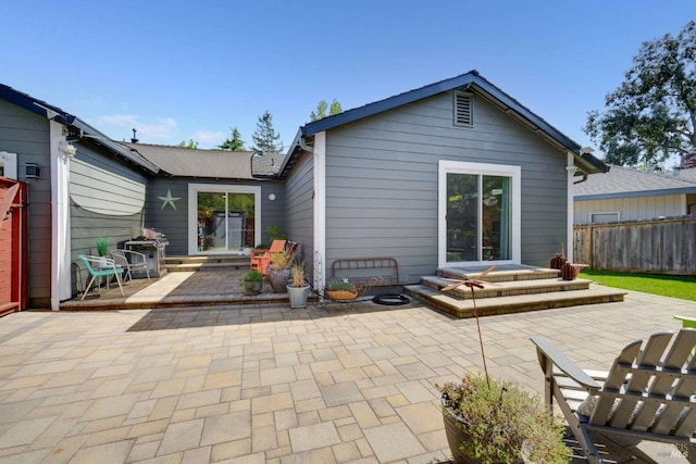rear view of house with a patio and fence