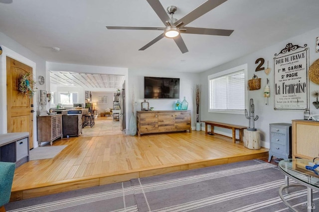 living area featuring light wood-style flooring and a ceiling fan