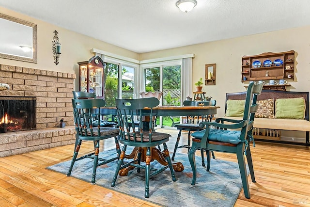 824 W St, Petaluma, CA 94952 - dining room with hardwood / wood-style flooring, a brick fireplace, and a textured ceiling