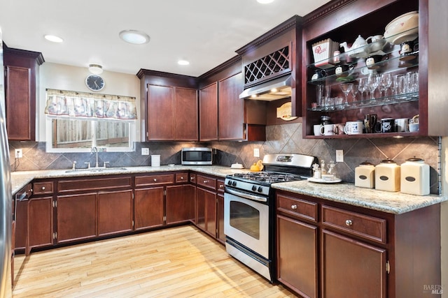 824 W St, Petaluma, CA 94952 - kitchen with appliances with stainless steel finishes, a sink, light wood-style flooring, light stone counters, and tasteful backsplash