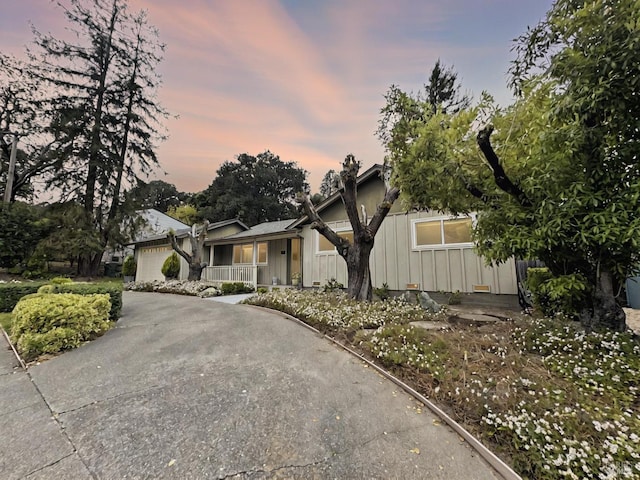 824 W St, Petaluma, CA 94952 - view of front of home with board and batten siding, a porch, driveway, and a garage