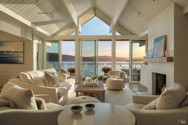 27 W Shore Rd, Belvedere, CA 94920 - living area with a water and mountain view, wood finished floors, beamed ceiling, a warm lit fireplace, and high vaulted ceiling