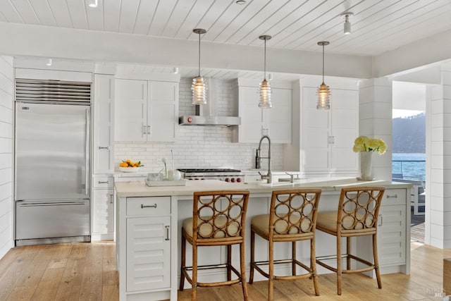 27 W Shore Rd, Belvedere, CA 94920 - kitchen with stainless steel built in fridge, light wood finished floors, a sink, decorative backsplash, and white cabinetry
