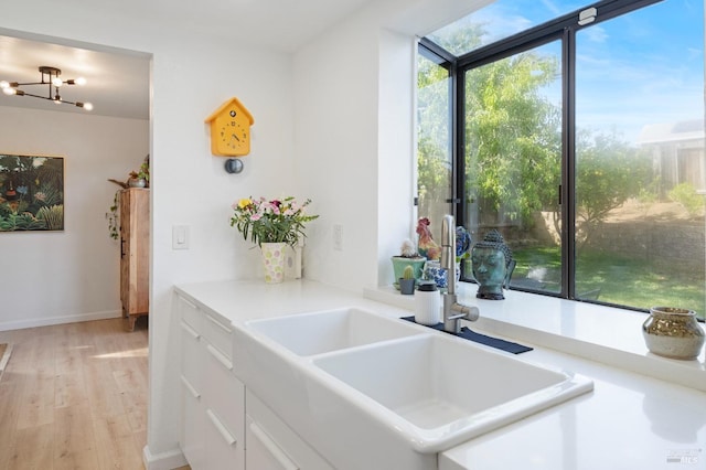624 N Regatta Dr, Vallejo, CA 94591 - kitchen featuring a sink, white cabinetry, light countertops, a notable chandelier, and light wood-style floors