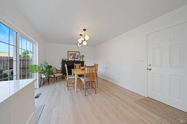 624 N Regatta Dr, Vallejo, CA 94591 - dining space with visible vents, a fireplace, an inviting chandelier, light wood-style flooring, and baseboards