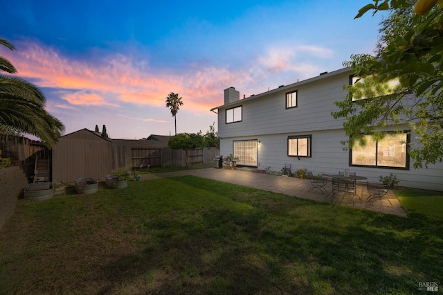 624 N Regatta Dr, Vallejo, CA 94591 - back of property at dusk with a yard, a patio area, a chimney, and fence