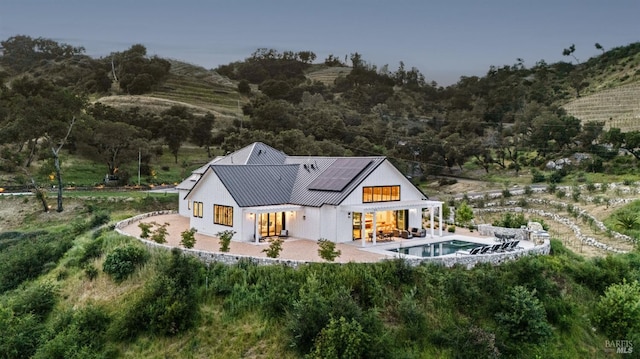 2509 Madrona Ave, Saint Helena, CA 94574 - back of house with an outdoor pool, a patio, metal roof, solar panels, and a standing seam roof