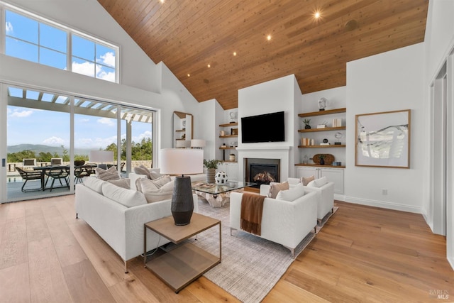 2509 Madrona Ave, Saint Helena, CA 94574 - living area with high vaulted ceiling, light wood-type flooring, a glass covered fireplace, wooden ceiling, and built in shelves