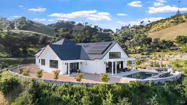 2509 Madrona Ave, Saint Helena, CA 94574 - back of house featuring metal roof, solar panels, a patio area, an outdoor pool, and a standing seam roof
