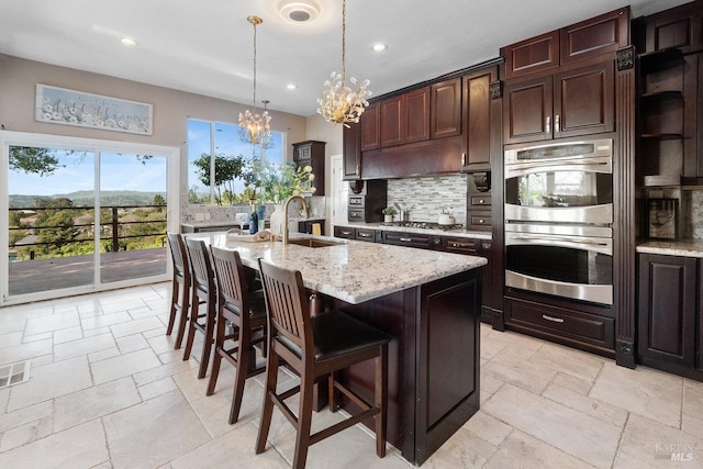 3580 Star Ridge Rd, Hayward, CA 94542 - kitchen featuring stone tile floors, a sink, a chandelier, backsplash, and appliances with stainless steel finishes