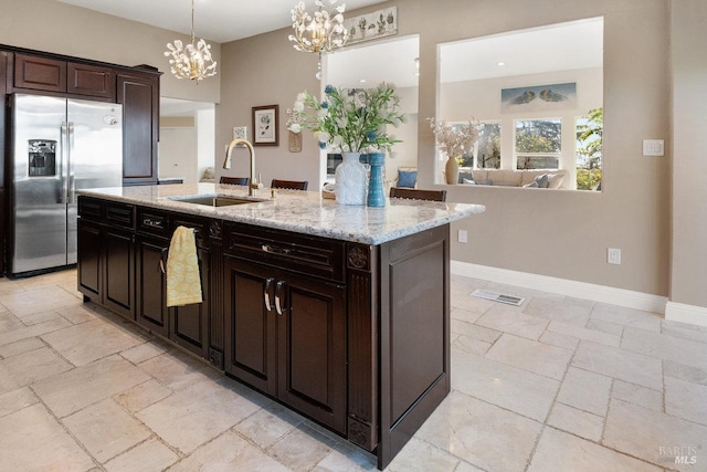 3580 Star Ridge Rd, Hayward, CA 94542 - kitchen with a sink, stone tile flooring, an island with sink, stainless steel fridge, and a notable chandelier