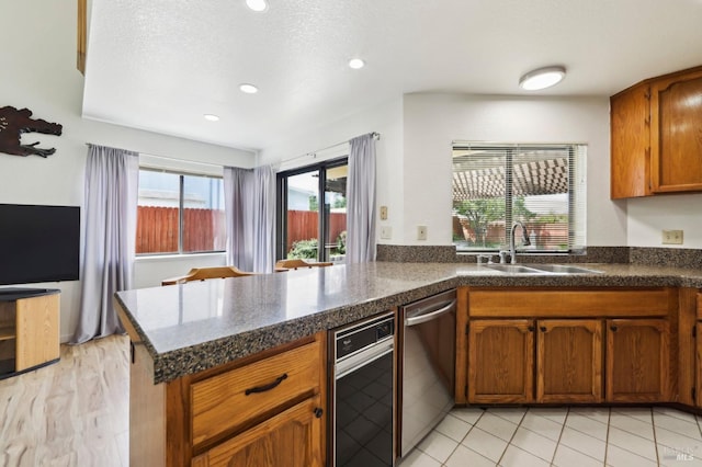 151 Doncaster Dr, Vallejo, CA 94591 - kitchen featuring a peninsula, a sink, dark countertops, brown cabinetry, and stainless steel dishwasher