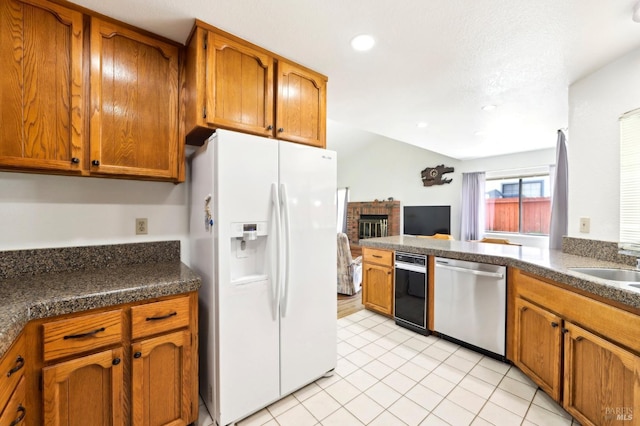 151 Doncaster Dr, Vallejo, CA 94591 - kitchen with dishwasher, white refrigerator with ice dispenser, brown cabinets, dark countertops, and a fireplace