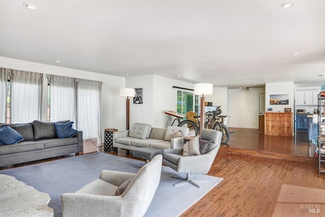 living area featuring recessed lighting, baseboards, and wood finished floors