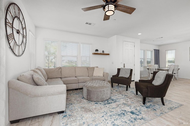 living room with light wood-type flooring, visible vents, recessed lighting, ceiling fan, and baseboards