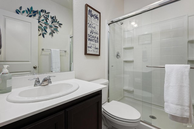 full bath with a shower stall, vanity, and toilet