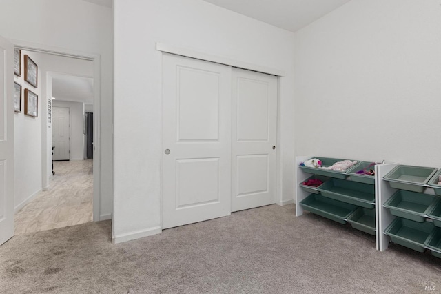 bedroom featuring baseboards, a closet, and carpet