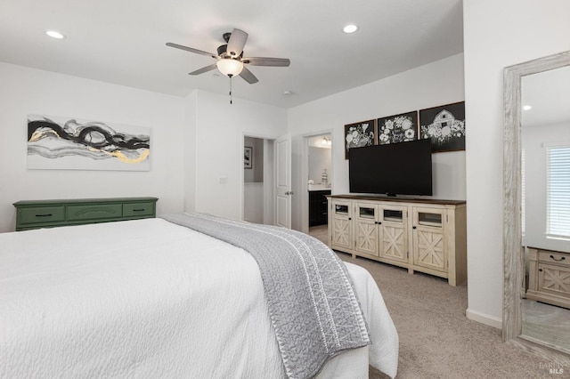 bedroom featuring recessed lighting, baseboards, ensuite bathroom, ceiling fan, and light carpet