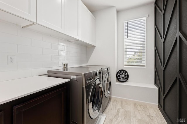 laundry area with washing machine and clothes dryer, cabinet space, and baseboards