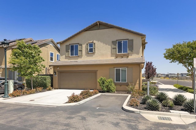 view of front of house featuring an attached garage, concrete driveway, stucco siding, and a tile roof