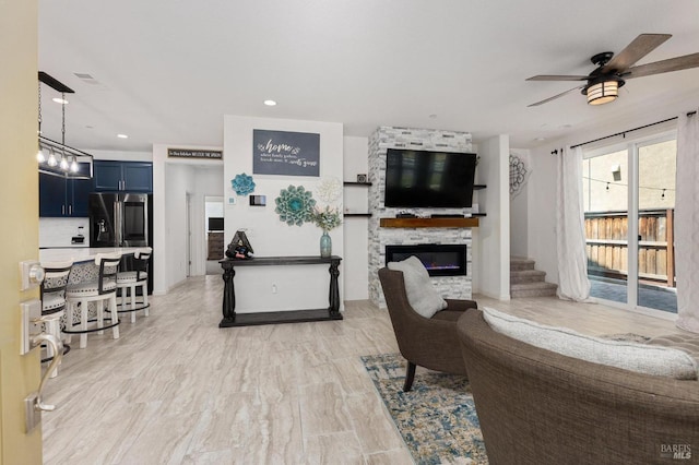 living area with visible vents, recessed lighting, a fireplace, ceiling fan, and stairway