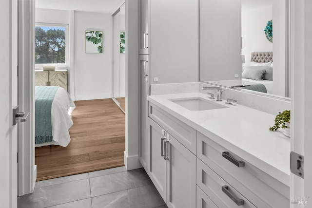 ensuite bathroom featuring vanity, connected bathroom, and wood finished floors