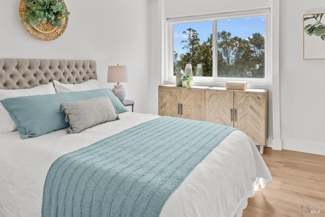 bedroom with baseboards and wood finished floors