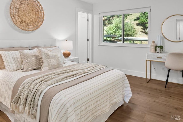 bedroom with wood finished floors and baseboards