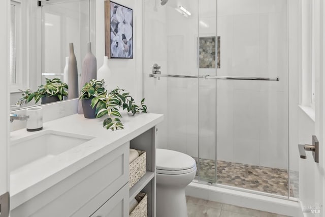 full bath with a stall shower, vanity, and toilet